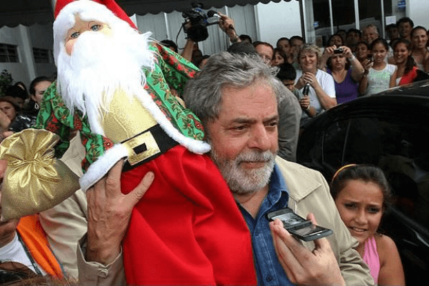 MARKETING ELEITORAL - O ex- presidente Luiz Inácio Lula da Silva carrega um Papai Noel que recebeu de presente durante visita aos desabrigados pelas enchentes em Blumenau - SC no dia 12 de dezembro de 2008.